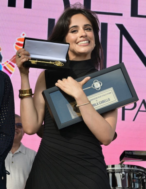 Camila Cabello à la Three Kings Parade, clé géante sourire politique