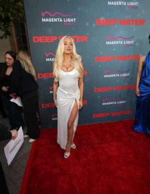 Lindsey Pelas noie le tapis rouge dans sa robe blanche fendue