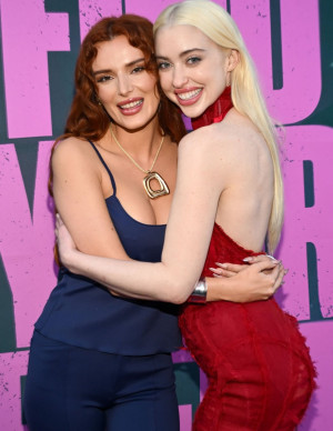 Bella Thorne pose en combinaison bleue devant le logo Find Your Friends