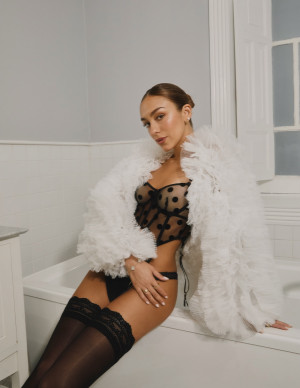 Luana Barron ose la lingerie Etam, plume blanche et bas noirs