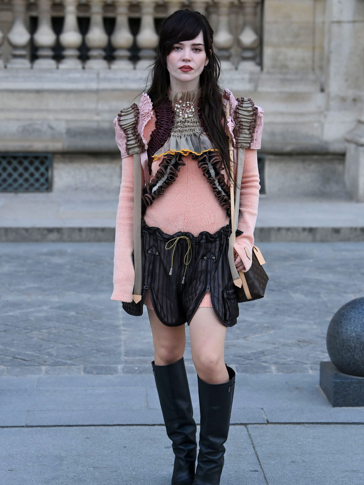 Sophie Thatcher au défilé Louis Vuitton : minijupe noire et cuisses dévoilées