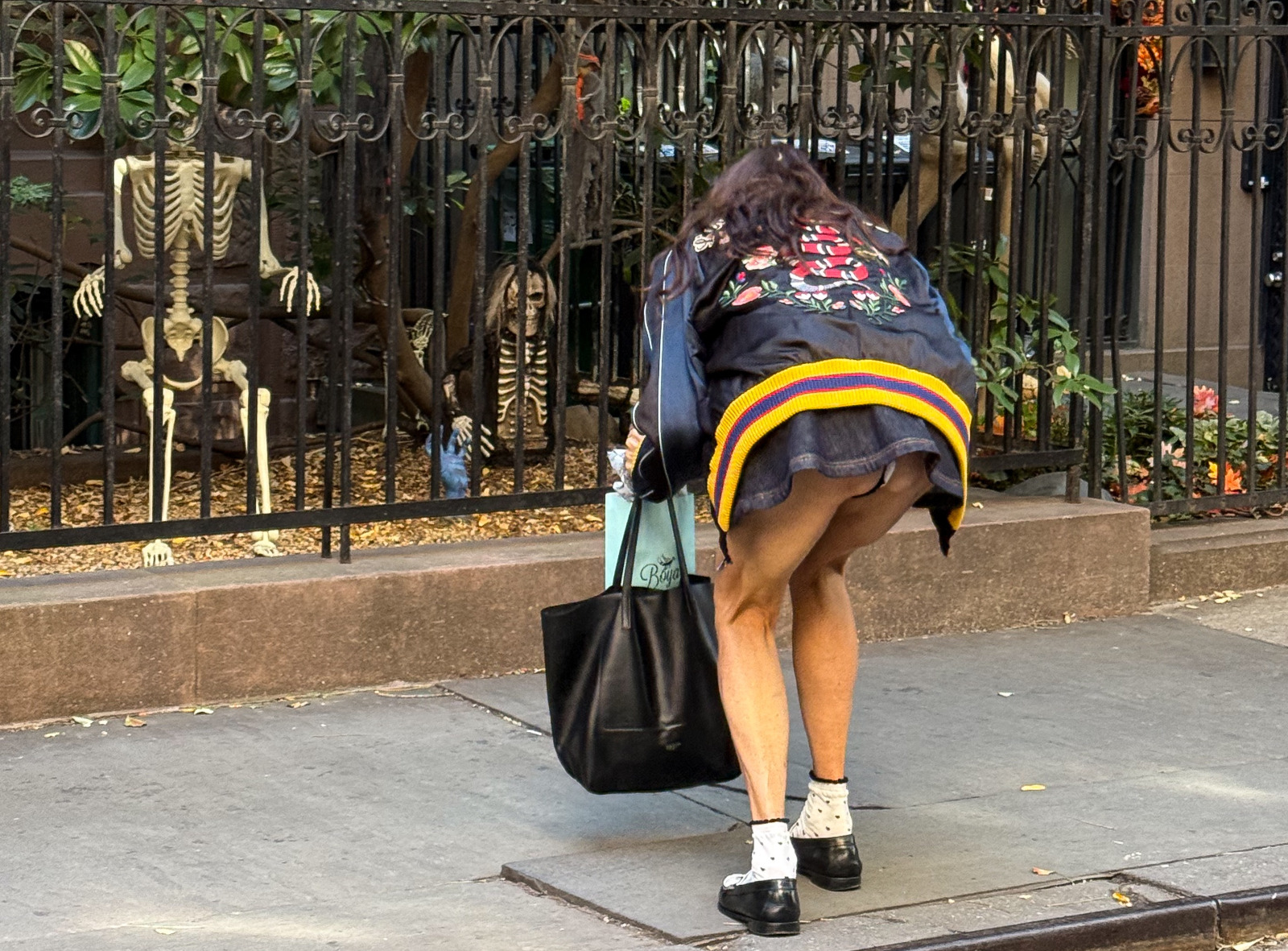 À New York, Famke Janssen se penche et sa minijupe remonte